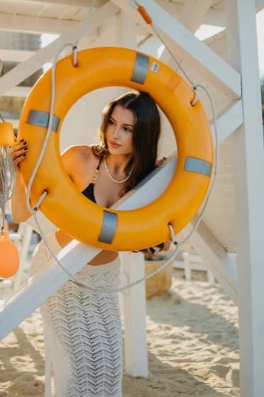 A woman looking out through an orange life ring.